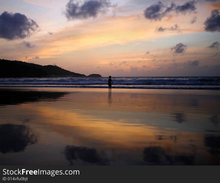 An image of a sunset on a beach with a boys silhouette. An image of a sunset on a beach with a boys silhouette.