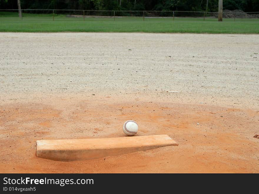 Single baseball on pitchers mound of empty field. Single baseball on pitchers mound of empty field.