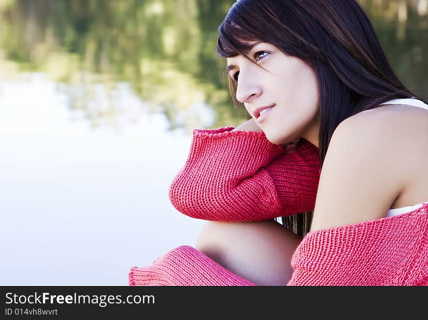 Young beautiful woman relaxing near water. Young beautiful woman relaxing near water.