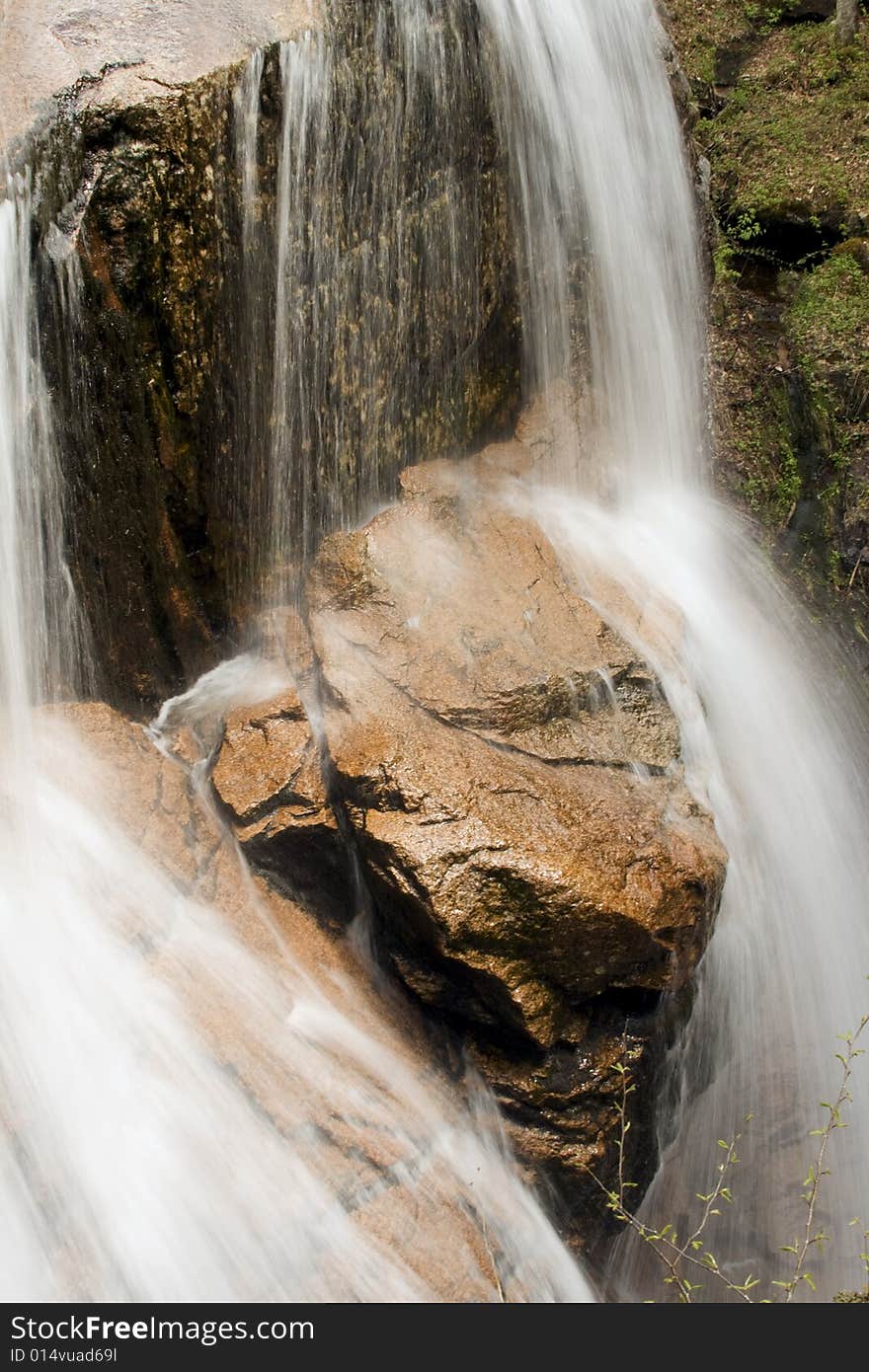 Small waterfall over red rock. Close up.