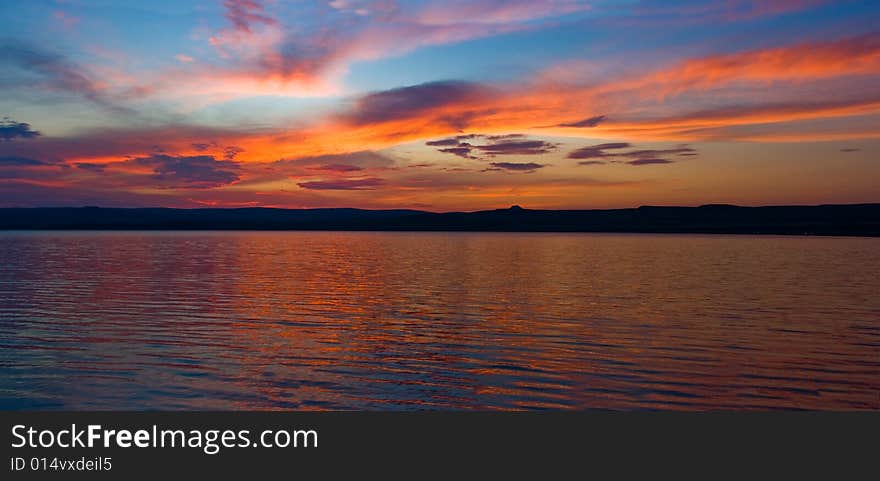 Sunset on the lake. Clouds, water and reflections. Great summer landscape.