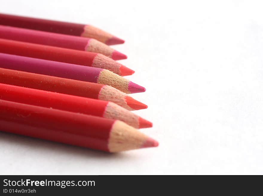 Different hues of red coloring pencils on white