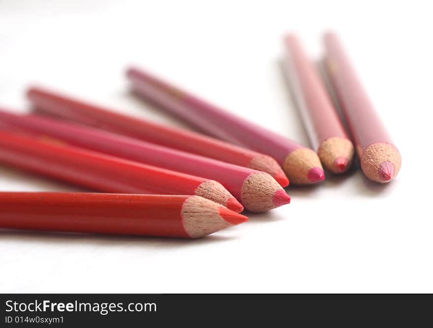 Different hues of red coloring pencils on white