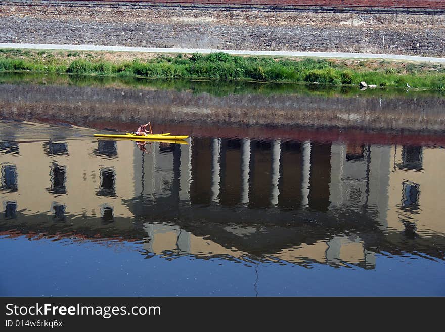 The Uffizzi Museum in Florence, reflected on the River Arno. A man canoing. The Uffizzi Museum in Florence, reflected on the River Arno. A man canoing