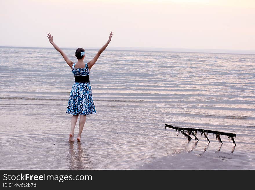 A girl goes on a bank on water. A girl goes on a bank on water