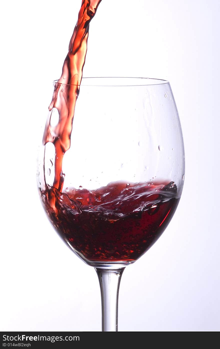 A stream of wine in a glass. A stream of wine in a glass