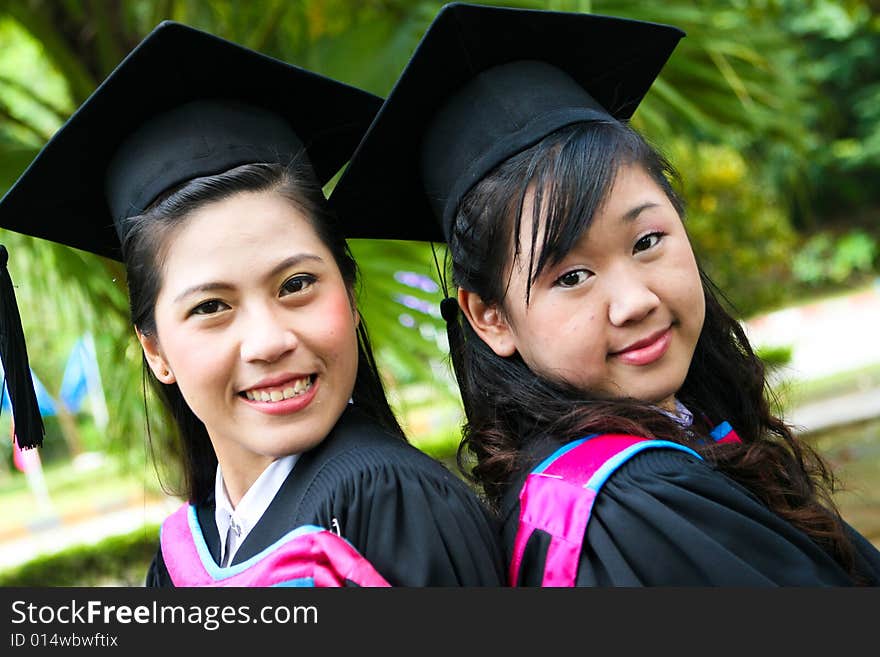 Gorgeous Asian university graduates celebrating their success.