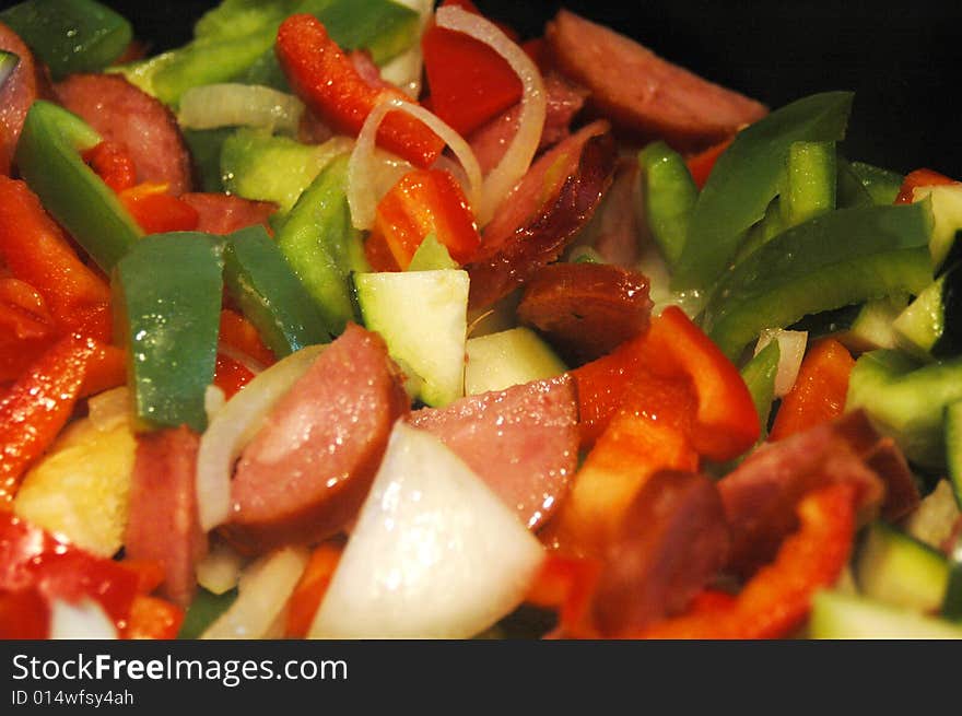 Mix of peppers, onion an sausage in a frying pan. Mix of peppers, onion an sausage in a frying pan