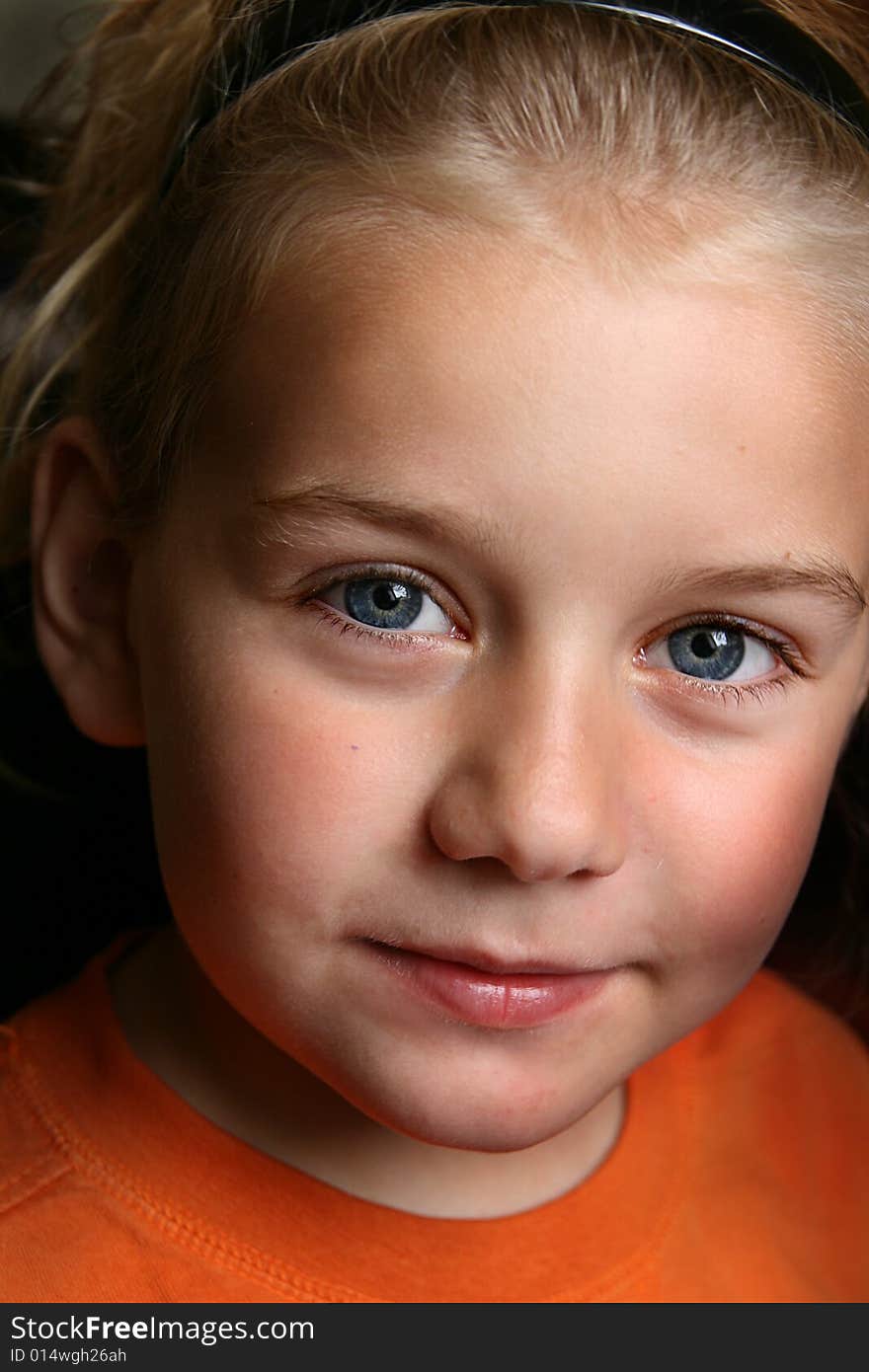 Portrait of boy with long blond hair looking at you