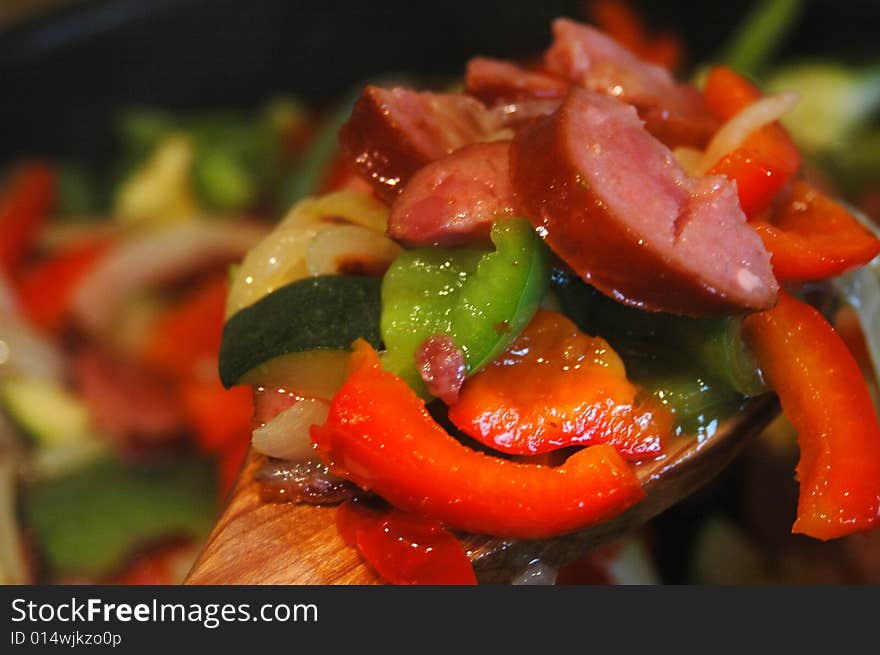 Mix of peppers, onion an sausage in a frying pan. Mix of peppers, onion an sausage in a frying pan