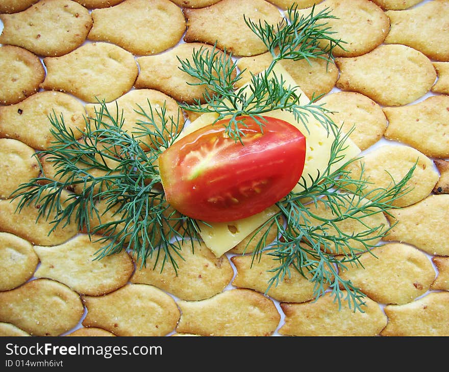 Tomato piece on cheese slice and cracker. Tomato piece on cheese slice and cracker