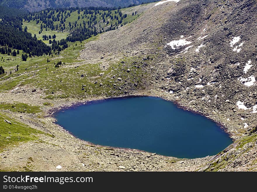 Lake in high mountains of Altai, summer, blue sky and white clouds