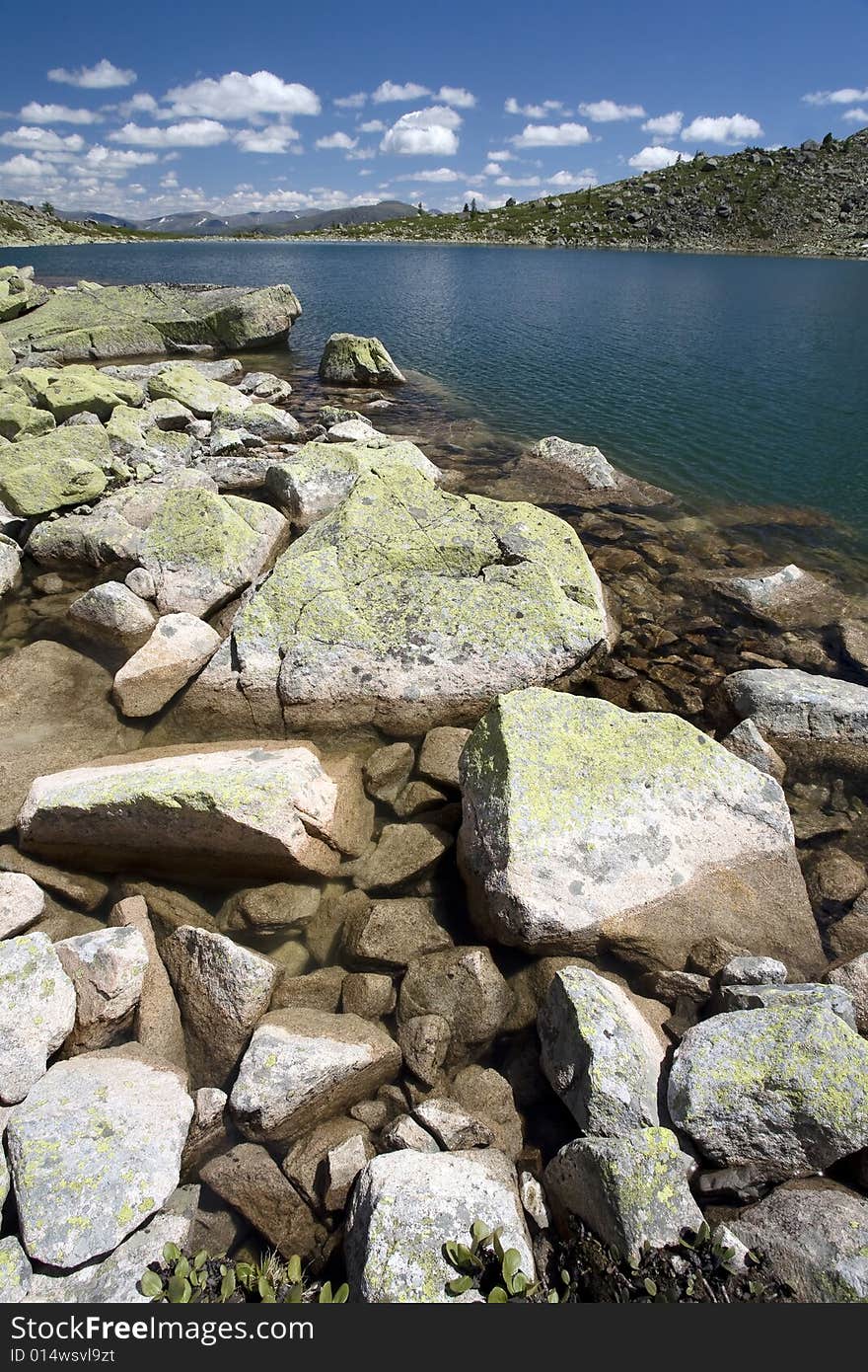 Lake in high mountains of Altai, summer, blue sky and white clouds