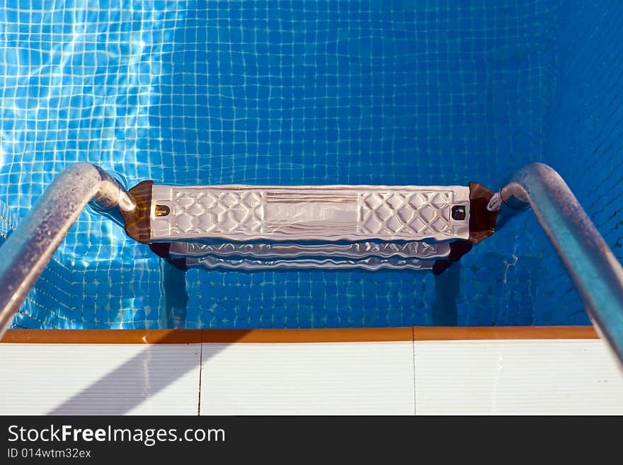 Swimming pool step with clear and blue water. Swimming pool step with clear and blue water