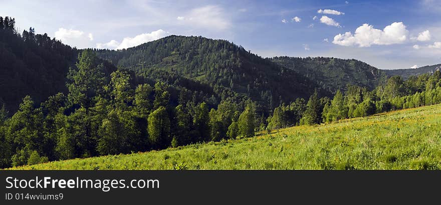 Panoramic picture in high mountains, summer, blue sky and white clouds