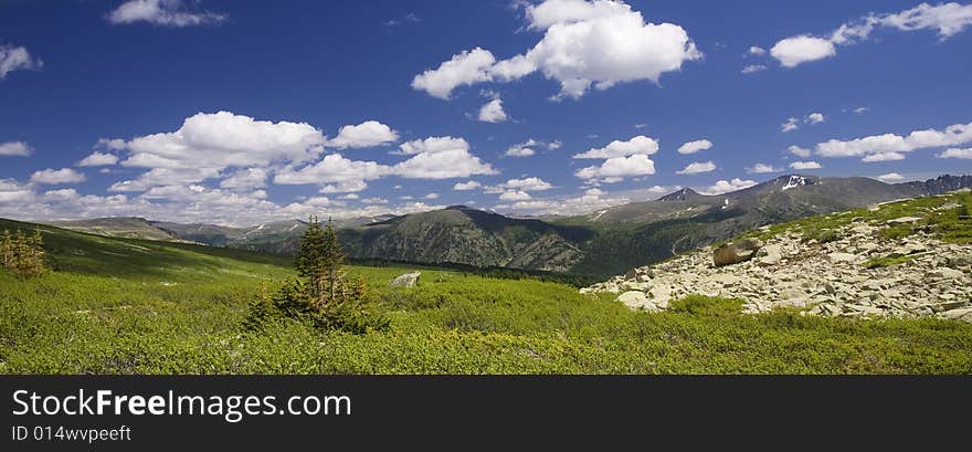 Panoramic picture in high mountains, summer, blue sky and white clouds