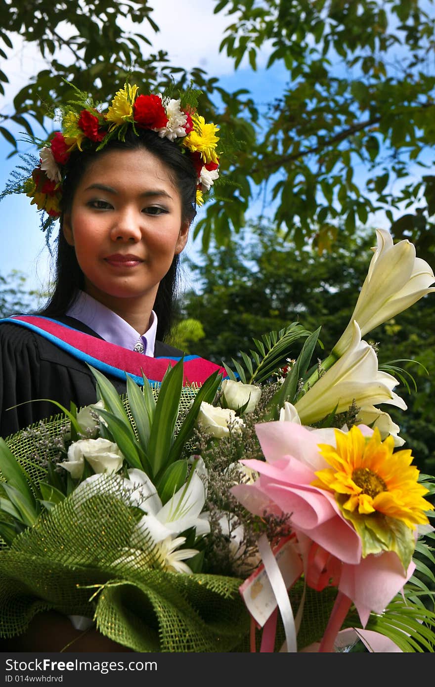 Beautiful young Asian graduate in robes on graduation day.