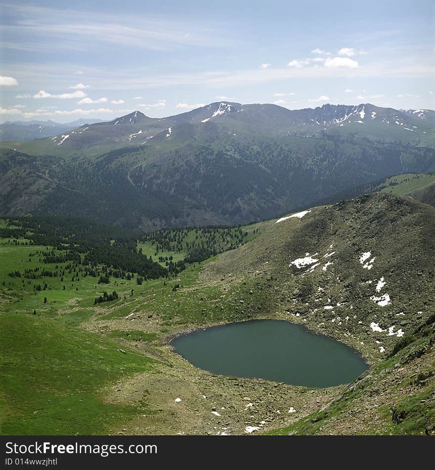 Lake in high mountains of Altai, summer, blue sky and white clouds