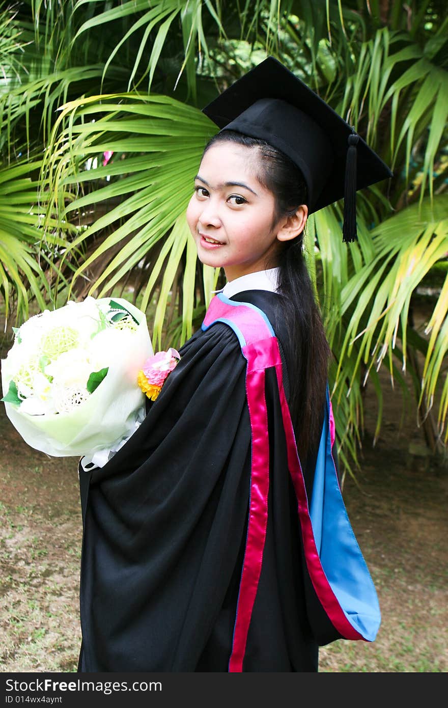 Beautiful young Asian graduate in robes on graduation day.