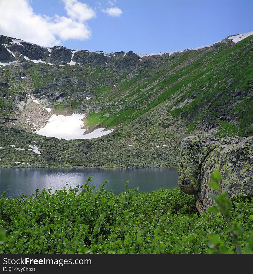 Lake in high mountains of Altai, summer, blue sky and white clouds