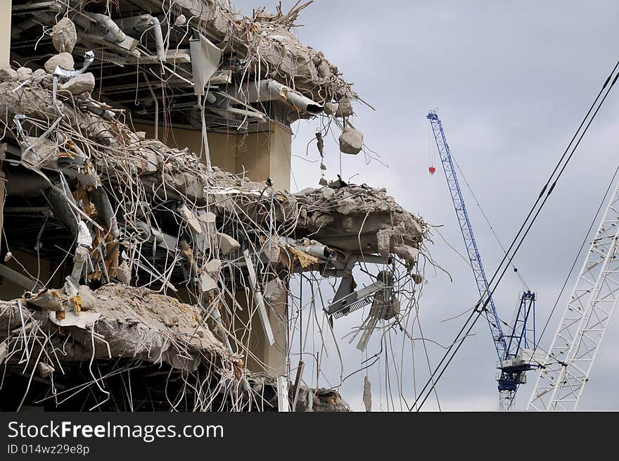 Building partially demolished with cranes, concrete and ducting exposed. Building partially demolished with cranes, concrete and ducting exposed