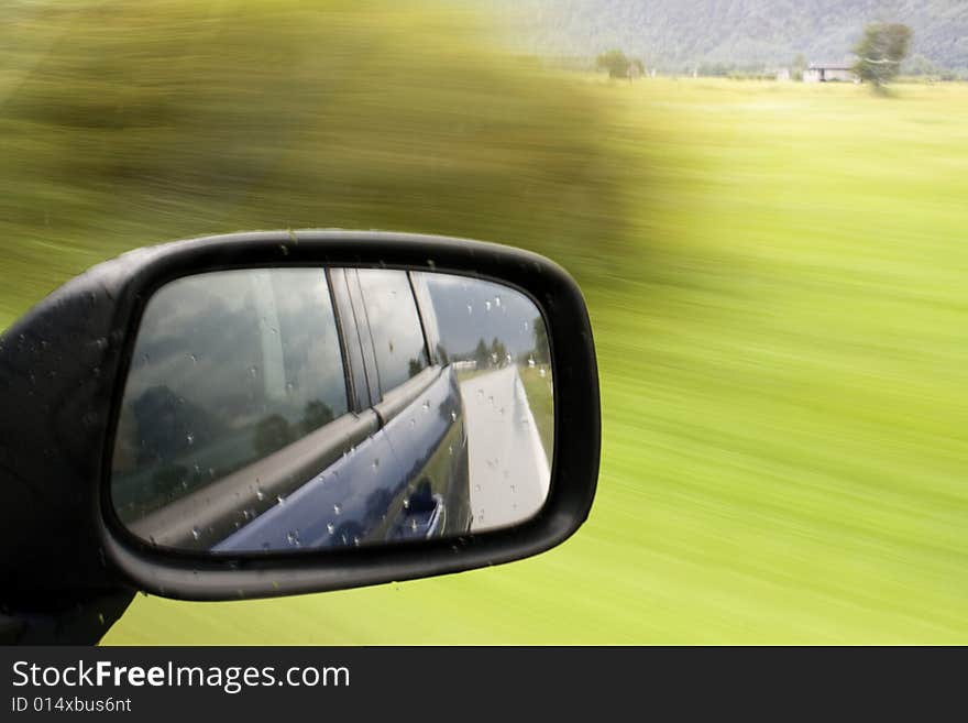 Side mirror of a car in motion. Side mirror of a car in motion