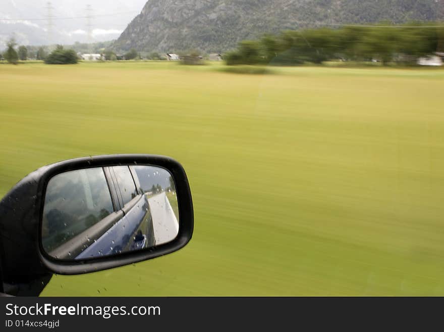 Side mirror of a car in motion. Side mirror of a car in motion