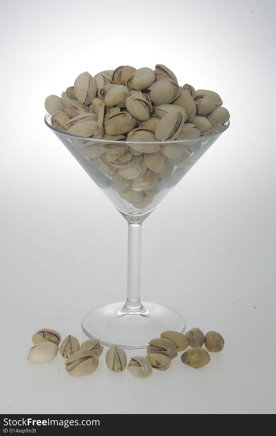 Pistachios in their shell, in a martini glass. Pistachios in their shell, in a martini glass