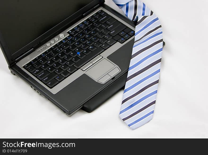 Laptop and tie on a white background