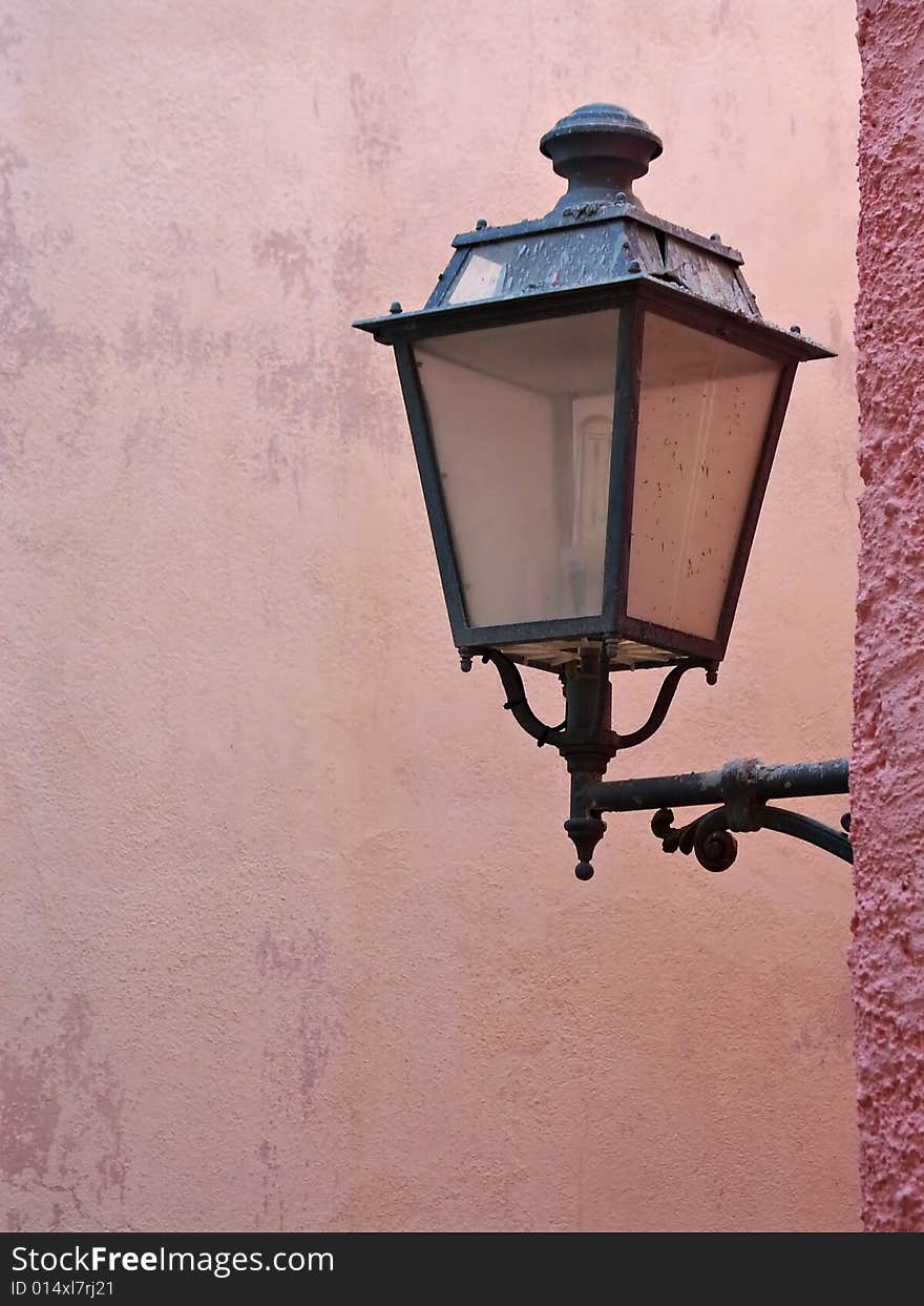 Street lamp hanging from a pink wall in Lisbon, Portugal. Street lamp hanging from a pink wall in Lisbon, Portugal