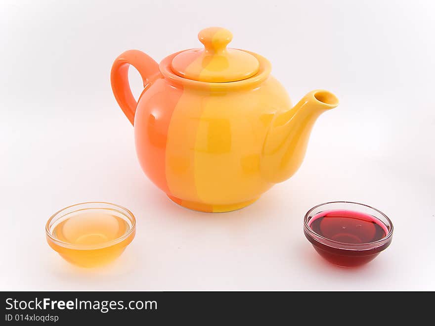 Teapot with red and yellow sirup on white. Teapot with red and yellow sirup on white