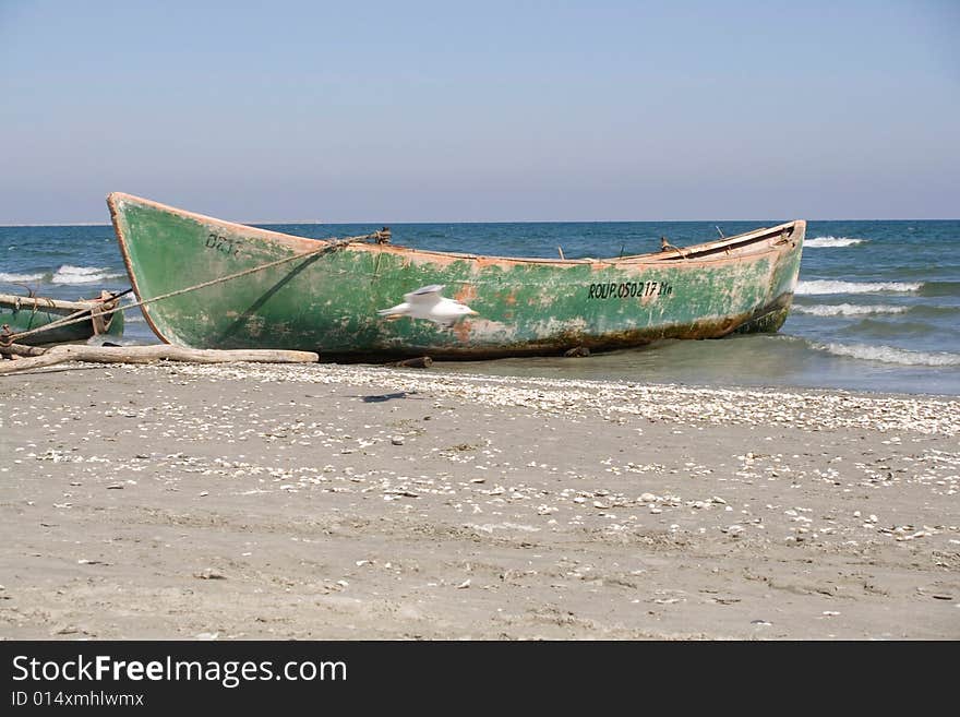 Green boat on the beach