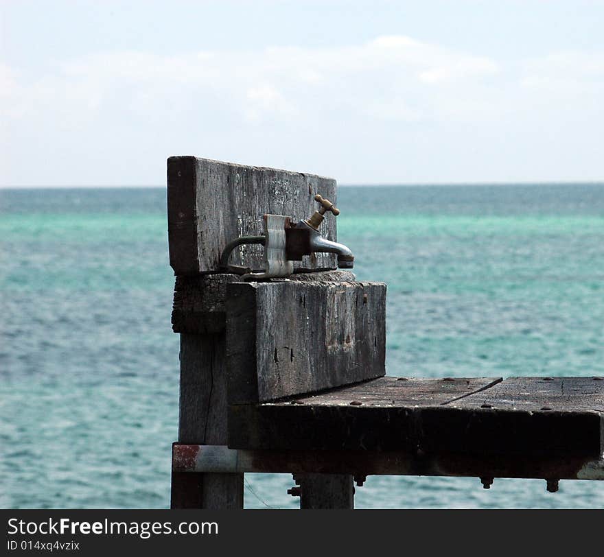 A water tap and ocean as background