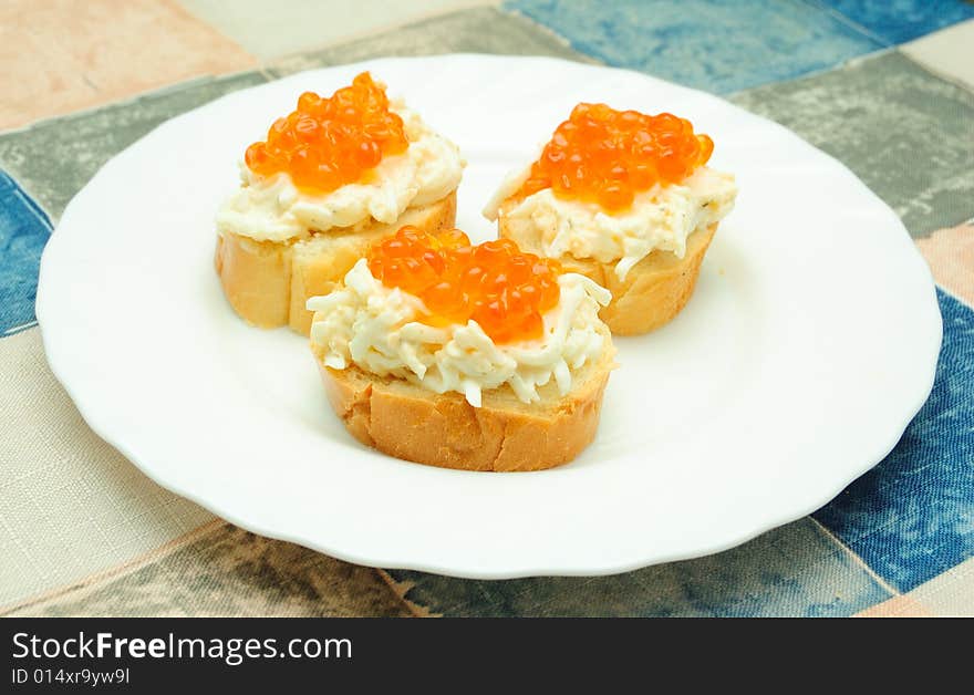 Three caviar sandwiches on white plate