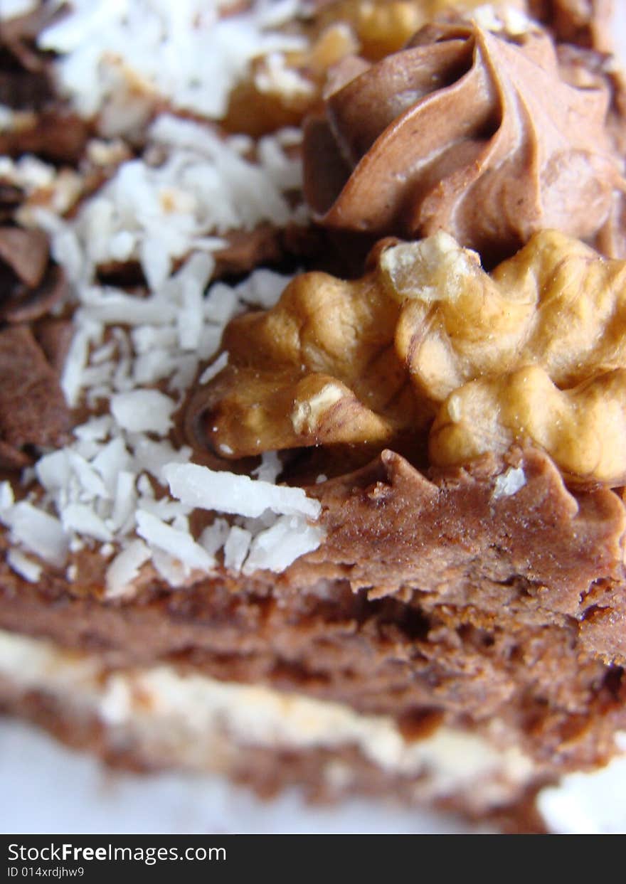 Chocolate cake covered with dried coconut, walnuts and coating glaze