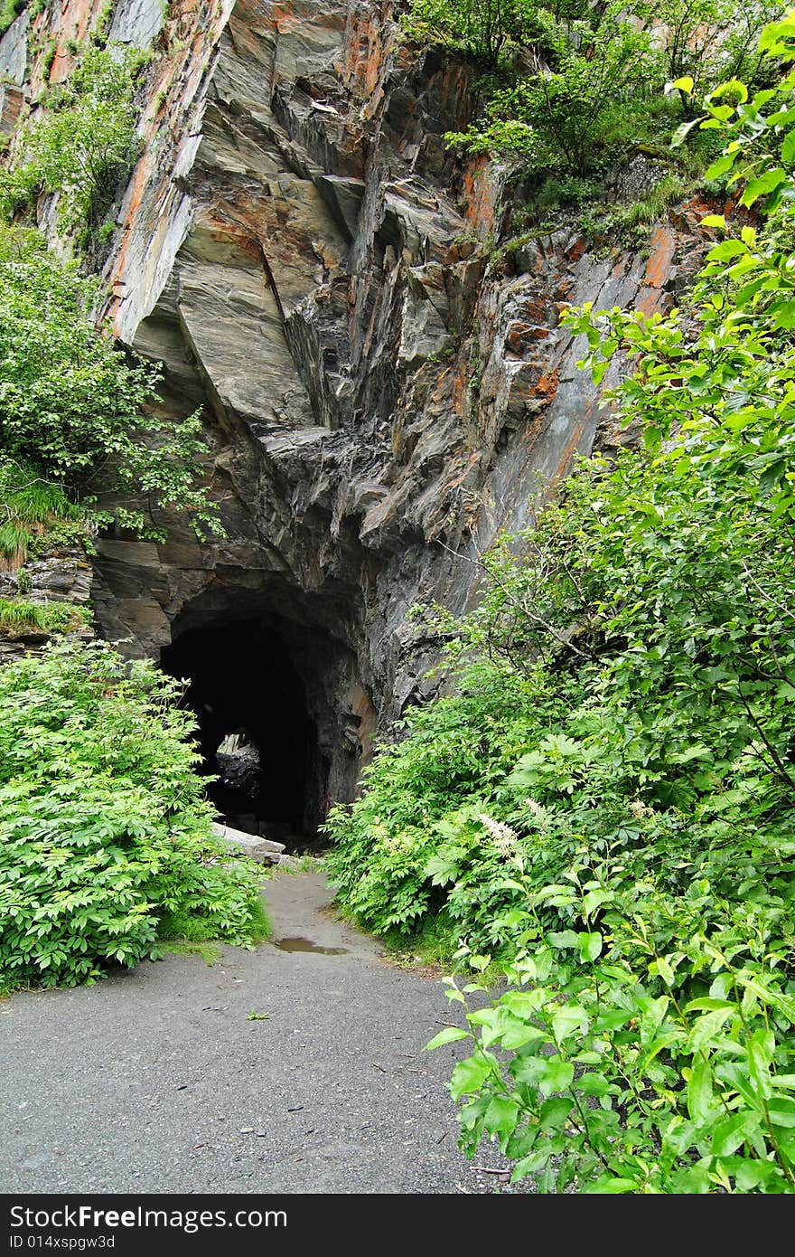 Entrance to an unfinished railroad tunnel cut into the rock of Keystone Canyon Alaska