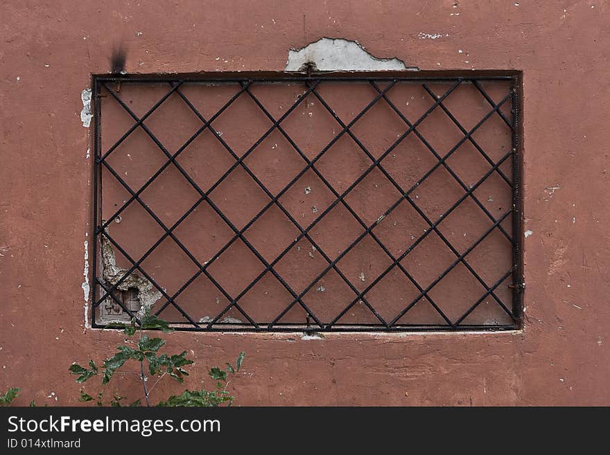 Locked window with black grate on it