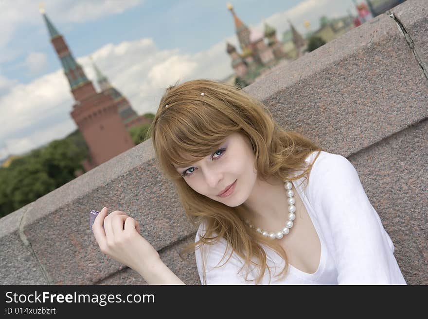 A photo of beautiful young woman near the Kremlin looking at camera. A photo of beautiful young woman near the Kremlin looking at camera