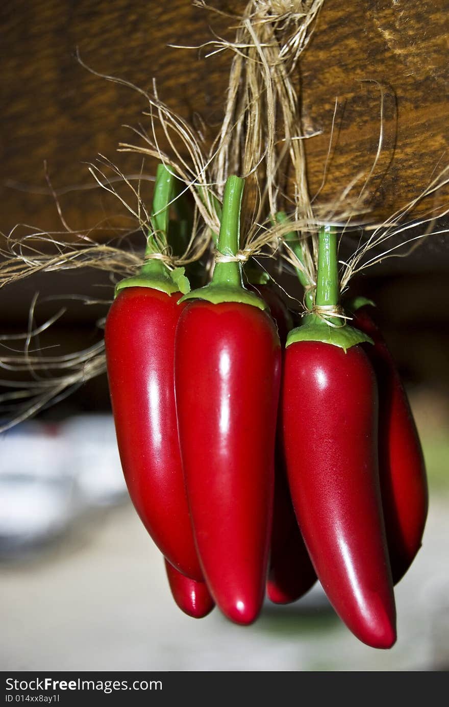 Many peppers suspended on a crossbeam. Many peppers suspended on a crossbeam