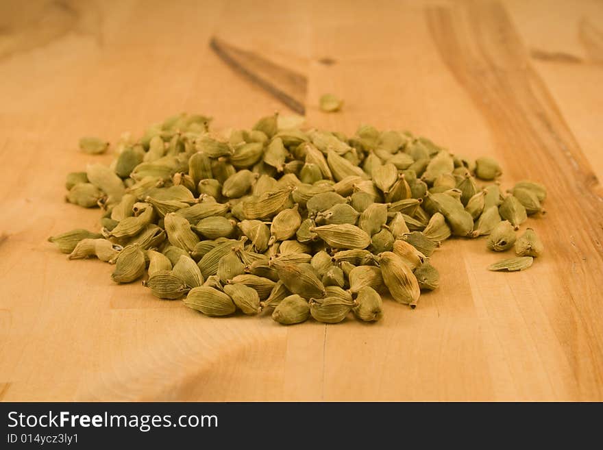 Cardamom fruits on wooden surface