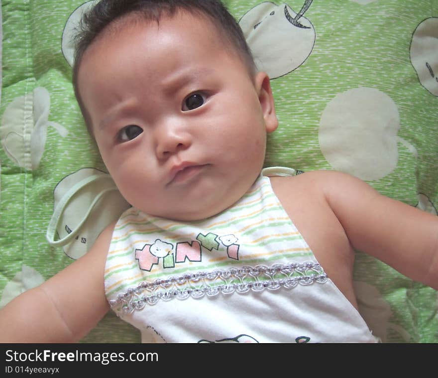 Lovely baby is lying down on a pillow