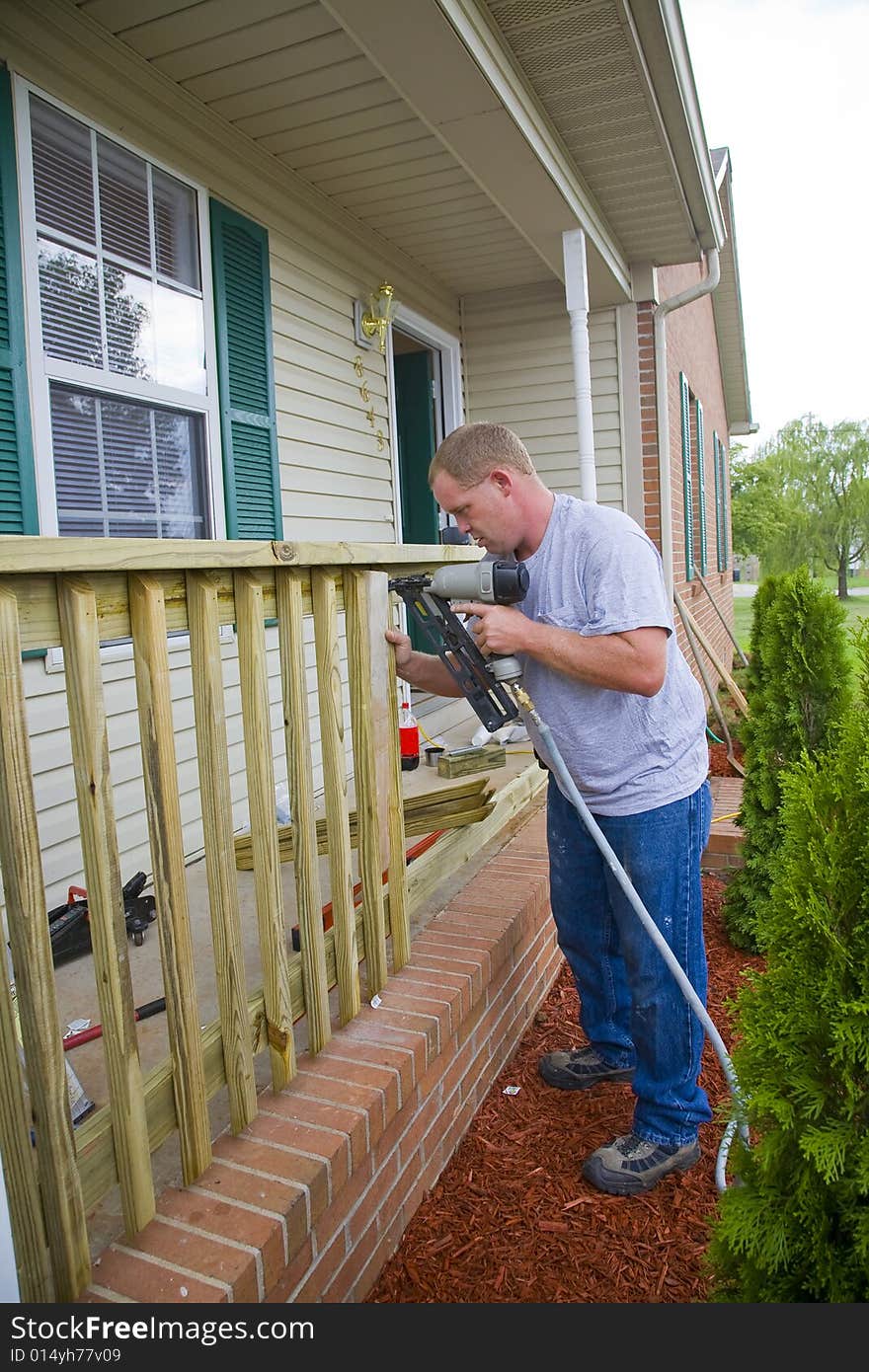 Carpenter is adding rails to porch on front of house, will add value for resale. Carpenter is adding rails to porch on front of house, will add value for resale