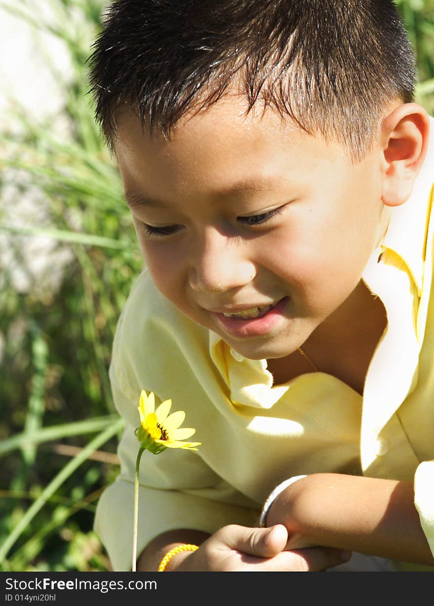 Young child smelling a yellow flower. Young child smelling a yellow flower