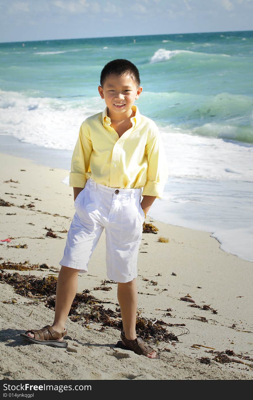 Young boy smiling and posing by the sea shore. Young boy smiling and posing by the sea shore