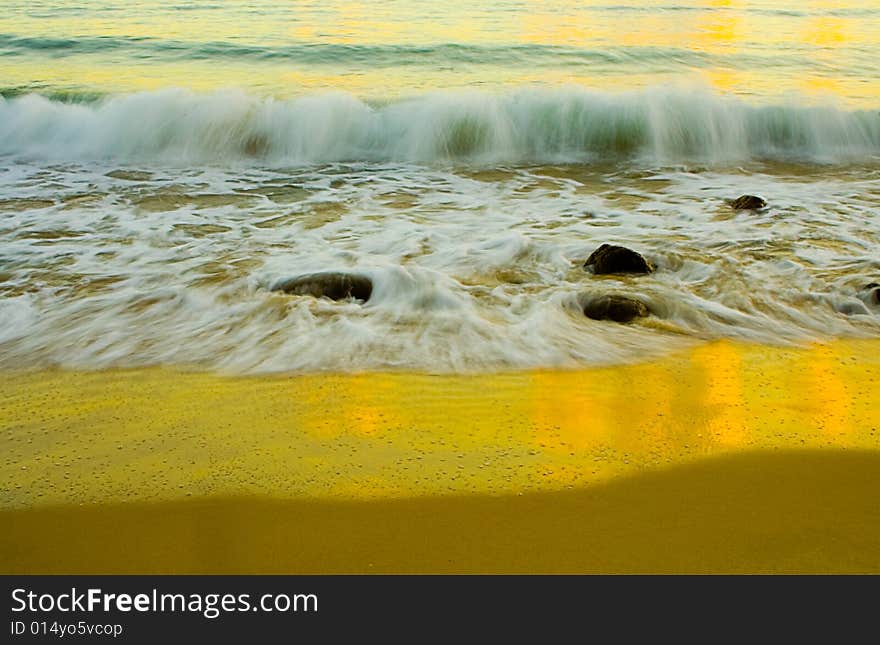 A Wave breaking on Noosa Beach at sunrise using a long exposure to blur water. A Wave breaking on Noosa Beach at sunrise using a long exposure to blur water