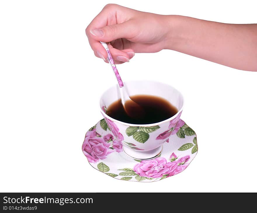 The female hand a spoon stirs tea or coffee