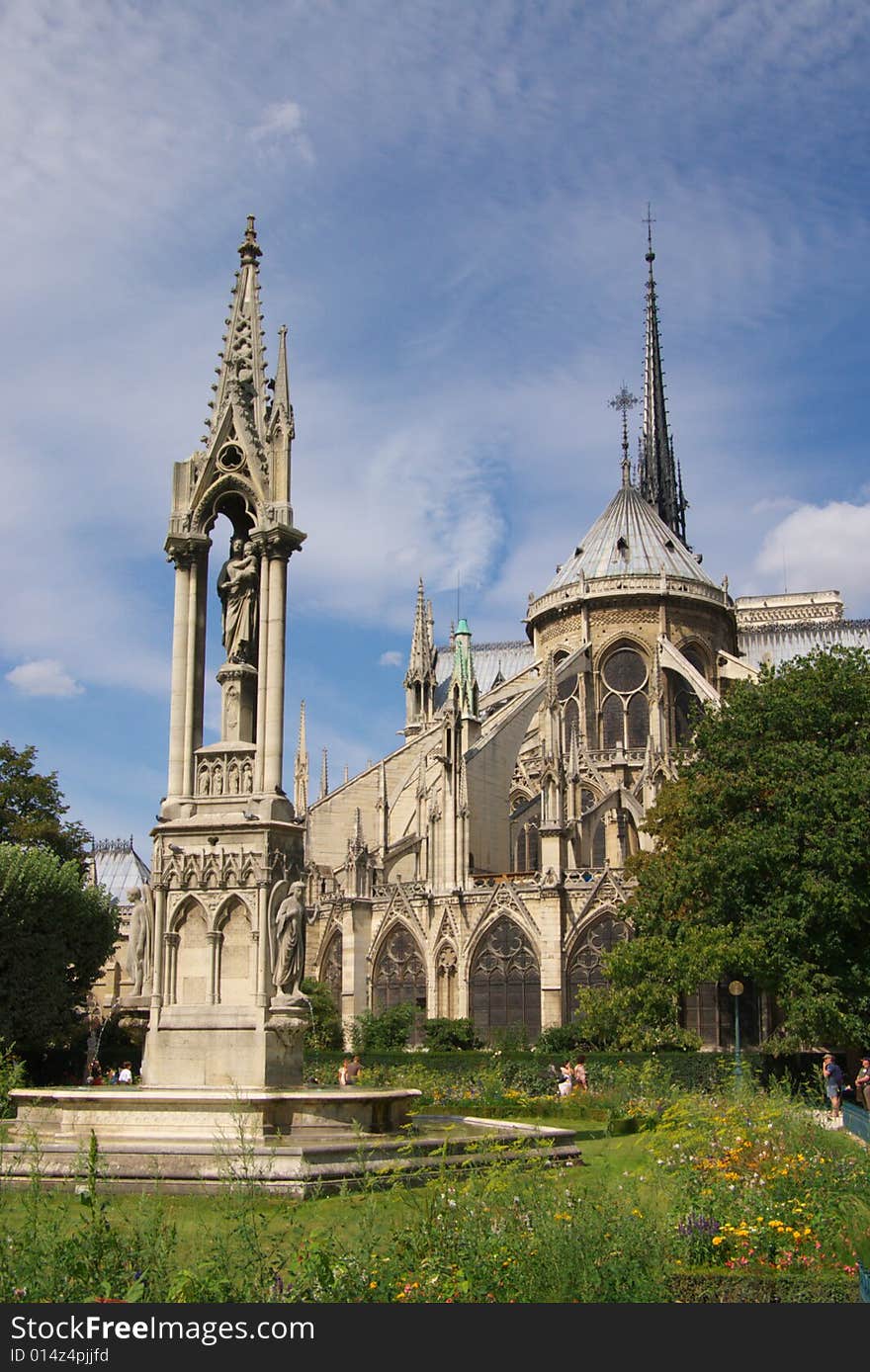 Notre Dam cathedral of Paris, vertical, blue sky and trees