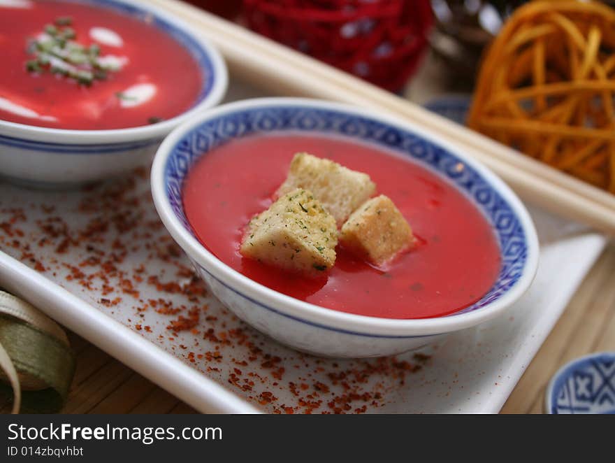 A soup of tomatoes with some croutons