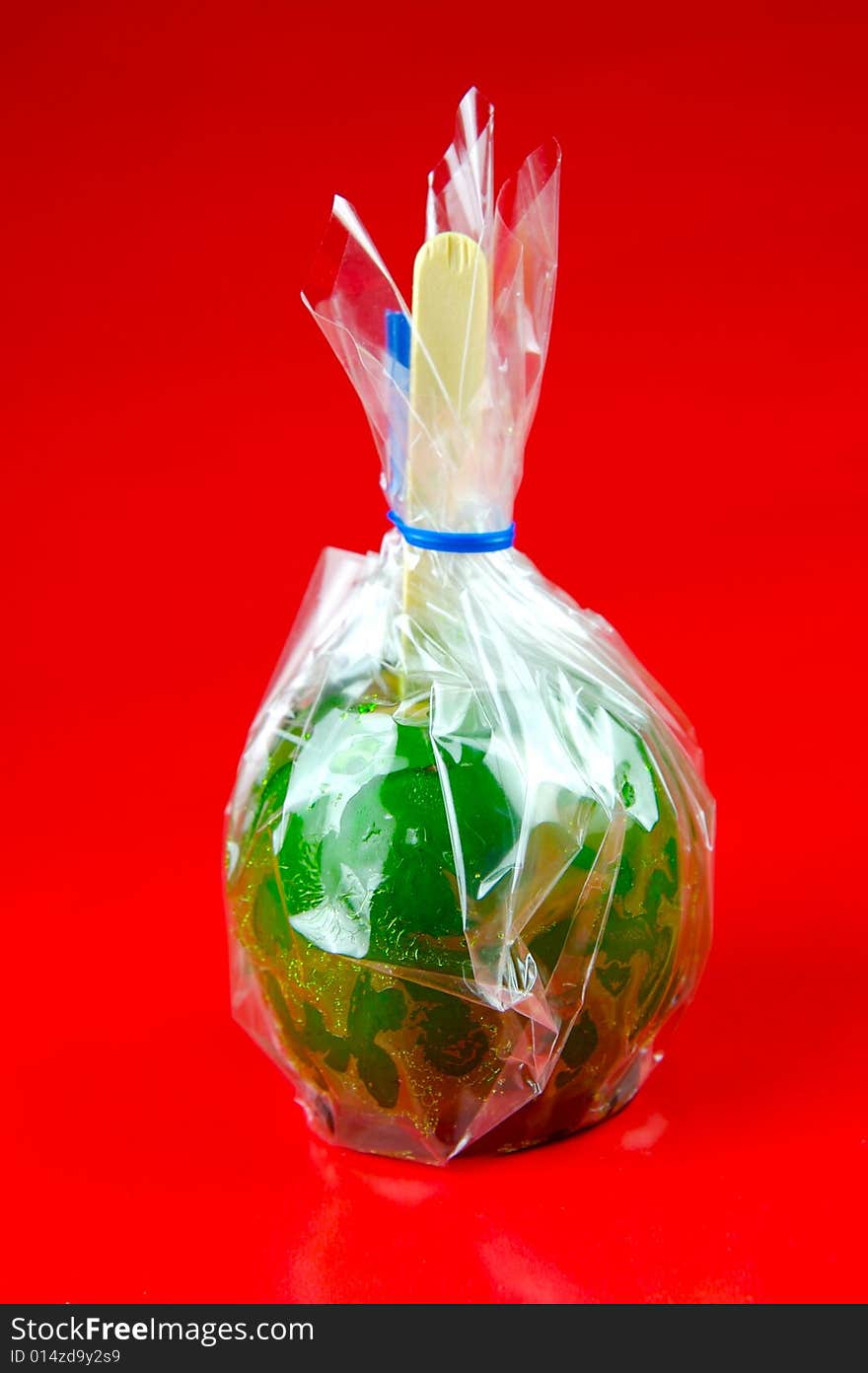 Toffee apples isolated against a green background