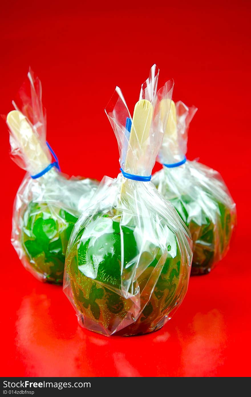 Toffee apples isolated against a green background